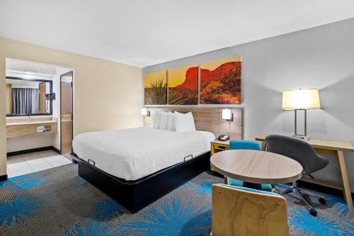 a hotel room with a bed and a table at Days Inn by Wyndham Tucson Airport in Tucson