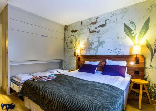 a bedroom with a large bed with purple pillows at Scandic Gävle Väst in Gävle