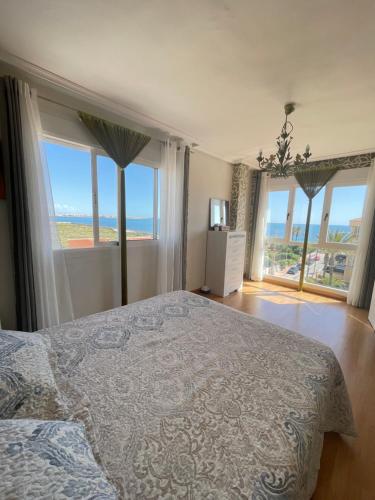 a bedroom with a bed with a view of the ocean at La dama del mar in Punta Prima
