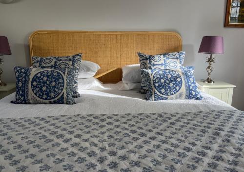 a bedroom with a bed with blue and white pillows at Stylish 1-bed Cottage Escape in Piddlehinton in Piddlehinton