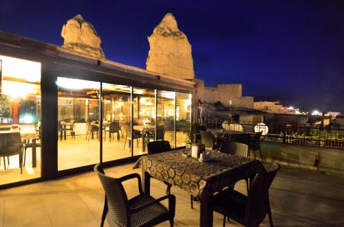 a table and chairs on a balcony at night at Relic House in Goreme