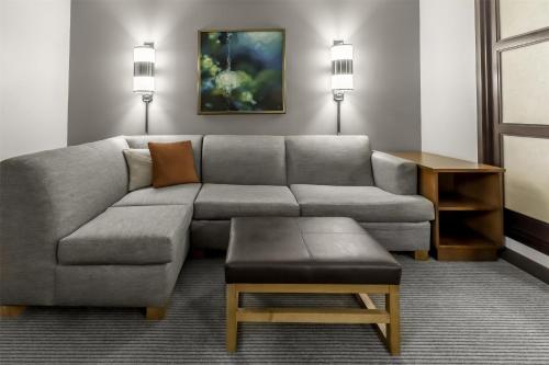 a living room with a couch and a table at Hyatt Place Charlotte Airport Billy Graham Parkway in Charlotte