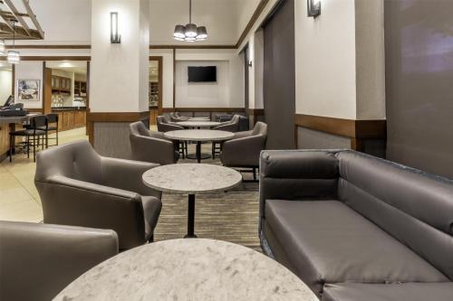 a waiting room with couches and tables at Hyatt Place Charlotte Airport Billy Graham Parkway in Charlotte