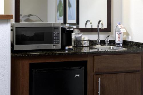 a kitchen with a microwave and a sink at Hyatt Place Charlotte Airport Billy Graham Parkway in Charlotte