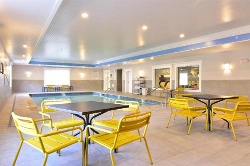 a pool room with tables and yellow chairs at Hampton Inn Bangor in Bangor