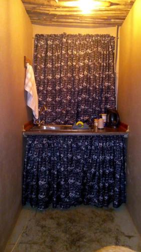 a room with a shower with a curtain and a table at Sabali in Rietfontein
