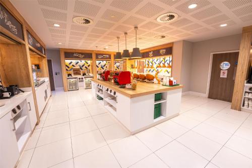 a large kitchen with a counter in a store at Hampton By Hilton Bristol Airport in Redhill