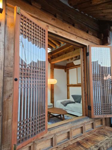 a room with a wooden door and a bedroom at Hanok Myeongdang in Gyeongju