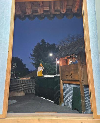 a view through a window of a yard at night at Hanok Myeongdang in Gyeongju