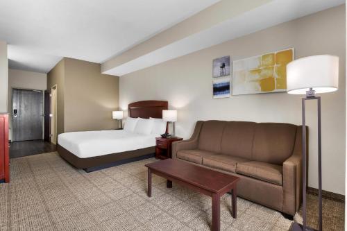 a hotel room with a bed and a couch at Comfort Inn & Suites North East in North East