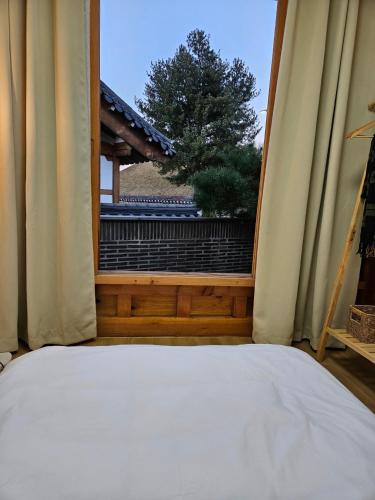 a bedroom with a window with a view of a garden at Hanok Myeongdang in Gyeongju
