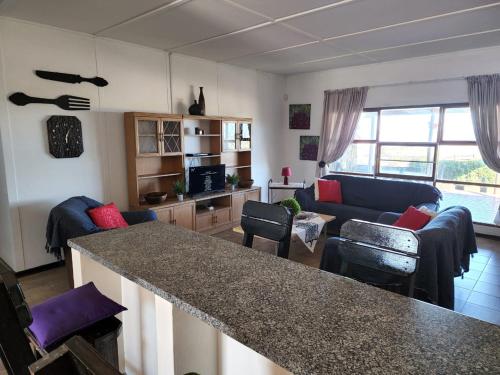 eine Küche und ein Wohnzimmer mit einer großen Arbeitsplatte in der Unterkunft DE SWARTE MOSSEL in Hondeklipbaai