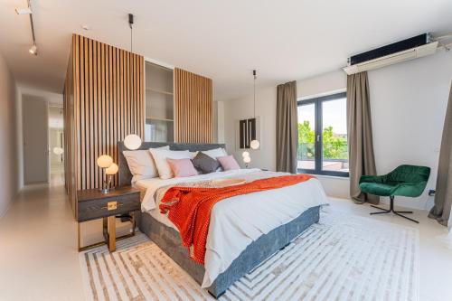 ein Schlafzimmer mit einem großen Bett und einem grünen Stuhl in der Unterkunft Flexible SelfCheckIns 140 - The most Luxurious Villa with Private pool in Zagreb in Zagreb