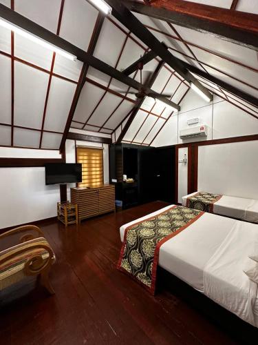 a bedroom with two beds and a television in it at National Park Mutiara - Kuala tahan in Kuala Tahan