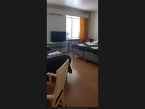 a room with two beds and a desk with a computer at Lentävä Kalakukko -Veturi B&B in Kuopio