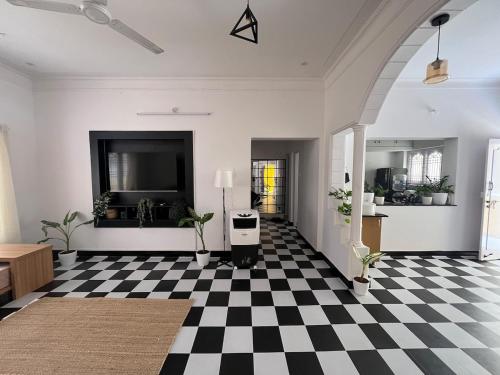 a living room with a black and white checkered floor at Sooru in Mysuru in Mysore