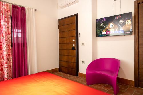 a bedroom with a purple chair and a tv at B&B Lilium Luxury Accomodations in Itri