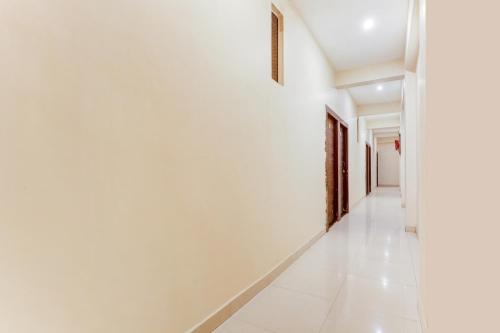 a hallway with white walls and white tile floors at Hotel O Radhika Royal in Nānta