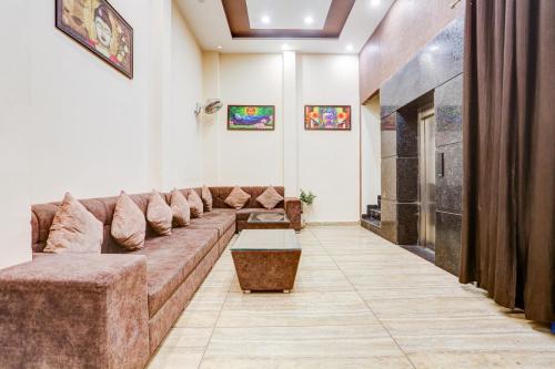 a living room with a long couch and a table at Hotel O Radhika Royal in Nānta