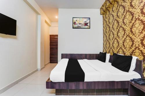 a bedroom with a bed with a black and white comforter at Hotel O Radhika Royal in Nānta