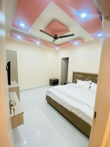 a bedroom with a bed and a ceiling with blue lights at Modest Rooms By Libra in Khizrābād