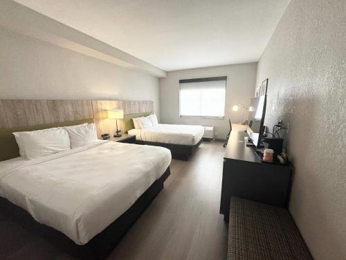 a hotel room with two beds and a window at Country Inn & Suites by Radisson, Port Charlotte, FL in Port Charlotte