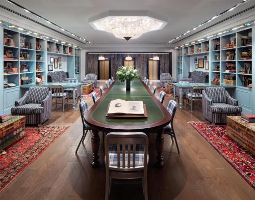 a dining room with a table and chairs and bookshelves at Graduate by Hilton State College in State College