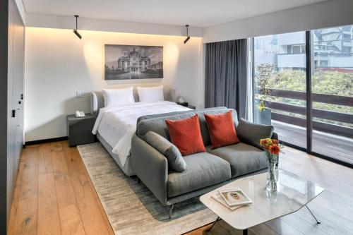 a hotel room with a bed and a couch at Amberes 64, an Ascend Collection Hotel in Mexico City