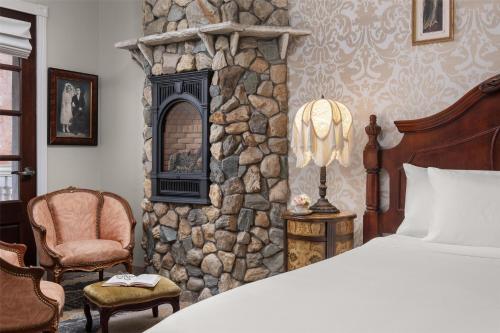 a bedroom with a bed and a stone wall at National Hotel Jackson, Tapestry Collection by Hilton in Jackson