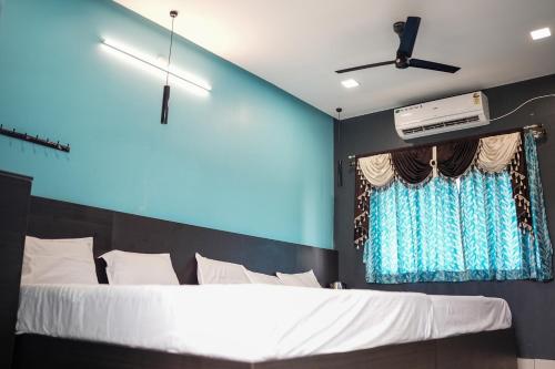 a bedroom with a large bed with a blue wall at H2cottage in Wodapatti
