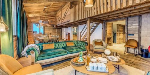 un salon avec un canapé vert et une table dans l'établissement Chalet Riva - Chalets pour 15 Personnes MAE-5863, à Aime La Plagne