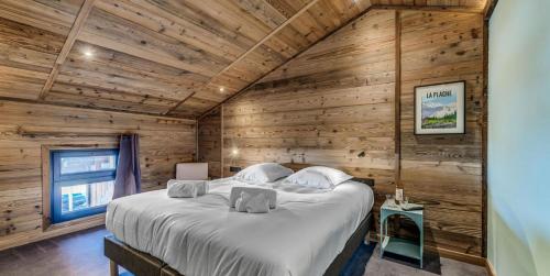 - une chambre avec des murs en bois et un grand lit dans l'établissement Chalet Riva - Chalets pour 15 Personnes MAE-5863, à Aime La Plagne