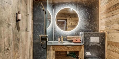 une salle de bain avec un lavabo et un miroir dans l'établissement Chalet Riva - Chalets pour 15 Personnes MAE-5863, à Aime La Plagne