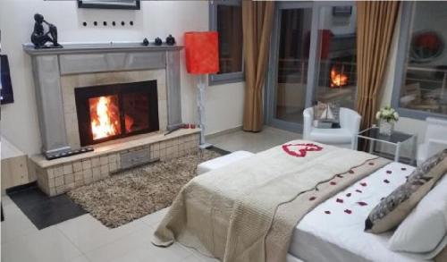 a living room with a fireplace and a couch at FOX Resort Hotel in Itʼkhvisi