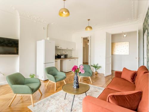 un salon avec un canapé, des chaises et une table dans l'établissement Merveil - Family Suite - Marais - Ponceau, à Paris