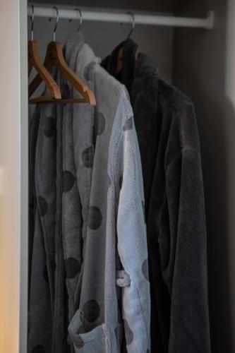 a row of shirts on a rack in a closet at B&B Het Gelders Buitenleven in Overasselt