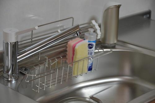 a kitchen sink with a dish drying rack on it at BEPPU つばき 一棟貸切宿 鉄輪温泉まで車で4分 石風呂付 無料駐車場3台 最大6名 wifi無料 in Beppu