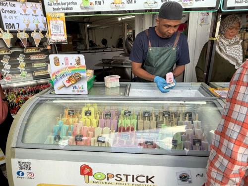 a man standing behind a food cart in a store at Nova Sunrise n Mountain view Hilltop Hotel apartment in Nova Cameron Highlands in Brinchang
