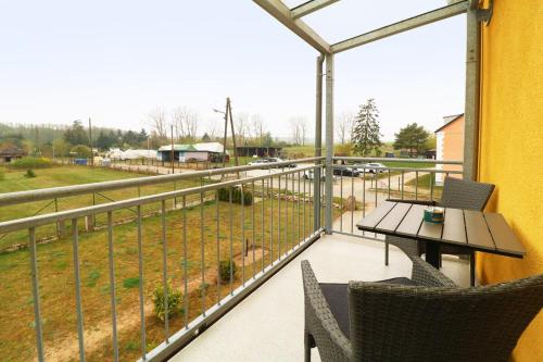 a balcony with a table and chairs and a view of a field at Ferienwohnung 4 in Zemitz