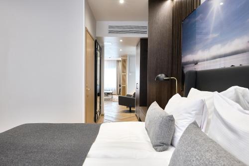a bedroom with a bed with white sheets and pillows at Hotel Verso in Jyväskylä
