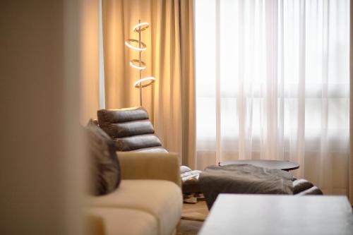 a living room with a couch and a chair and a window at Hotel Verso in Jyväskylä