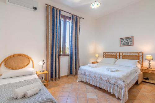 Un dormitorio con dos camas y una ventana. en Casa del limoneto di Corrado Fronte, en Noto