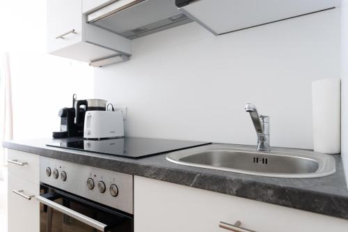 a kitchen with a sink and a counter top at Central Modern Studio Apartment with Free Parking in Vienna