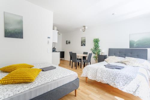 a bedroom with two beds and a table with chairs at Central Modern Studio Apartment with Free Parking in Vienna
