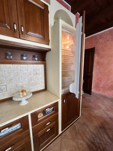 Una cocina con gabinetes de madera y un refrigerador abierto. en Appartamento Florinella, en Ospedaletto