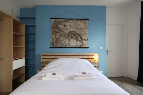 - une chambre avec des murs bleus et un lit avec 2 serviettes dans l'établissement Vernouillet charmant T3 situé à deux pas du centre, à Reims