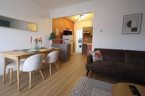 Il comprend un salon et une cuisine avec une table et un canapé. dans l'établissement Vernouillet charmant T3 situé à deux pas du centre, à Reims