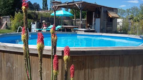 une grande piscine avec une clôture en bois et des fleurs dans l'établissement loft appartement dans bastide, à La Celle-sous-Gouzon