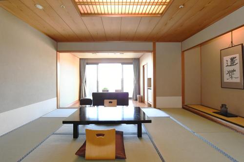 a living room with a table and a chair at Shimoda Yamatokan in Shimoda