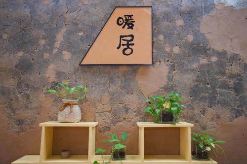two tables with plants and a sign on a wall at 平潭游记猫头墘古村落 in Pingtan